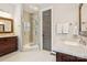 This primary bath has double sinks, a glass shower enclosure and light colored floors at 2221 Kenmore Ave, Charlotte, NC 28204