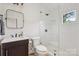 Bathroom featuring a dark vanity, modern fixtures, and a glass enclosed shower with subway tile at 2221 Kenmore Ave, Charlotte, NC 28204