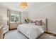 Bedroom boasts natural light, dresser with decor, white bedding, and hardwood floors at 2221 Kenmore Ave, Charlotte, NC 28204