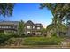 Charming two-story home with a landscaped front yard, covered porch, and steps leading to the entrance at 2221 Kenmore Ave, Charlotte, NC 28204