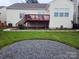A spacious backyard with a wooden deck, stone firepit area, and lush lawn at 2226 Elendil Ln, Charlotte, NC 28269