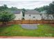 View of the backyard, with a firepit, lawn, and a wooden fence, offering privacy at 2226 Elendil Ln, Charlotte, NC 28269