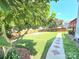 Landscaped backyard with mature trees, green grass, paved walkway and a wooden fence at 2226 Elendil Ln, Charlotte, NC 28269