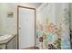 A bathroom featuring a shower with a floral curtain and a white door on wood-look floors at 231 Valley View Dr, Clover, SC 29710