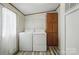 Laundry room features side-by-side washer and dryer, cabinetry and white door to outside at 231 Valley View Dr, Clover, SC 29710