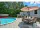 Pool area with table, seating, and large umbrella outside a home with green foliage at 231 Valley View Dr, Clover, SC 29710