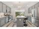 Well-lit kitchen featuring stainless steel appliances, grey cabinets, and an island with seating at 235 S Bruns Ave, Charlotte, NC 28208