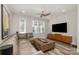 Modern living room with large sectional couch, stylish ottoman, and big-screen television at 235 S Bruns Ave, Charlotte, NC 28208