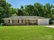 A well-maintained, brick home showcasing a cozy front porch with rocking chairs and black shutters accenting the windows at 2451 Robert H Kirk Rd, Lancaster, SC 29720