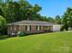 A charming brick house is surrounded by a well-maintained lawn and lush greenery at 2451 Robert H Kirk Rd, Lancaster, SC 29720