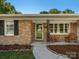 Close-up of front porch featuring brick facade, rocking chairs, and decorative front door with concrete walkway at 2451 Robert H Kirk Rd, Lancaster, SC 29720