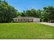 Charming brick home featuring a well-manicured lawn, mature trees, and an attached garage, offering classic curb appeal at 2451 Robert H Kirk Rd, Lancaster, SC 29720