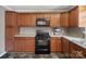 Kitchen featuring wooden cabinets, black appliances, and sleek countertops at 2451 Robert H Kirk Rd, Lancaster, SC 29720