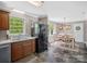 Open kitchen and dining area with wood cabinets, sleek black appliances, and ample lighting at 2451 Robert H Kirk Rd, Lancaster, SC 29720