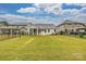 Wide green backyard with lush grass and trees, next to a screened patio at 2760 Berkhamstead Cir, Concord, NC 28027