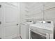 Convenient laundry room with modern washer and dryer, shelving for storage, and a door to exit at 2760 Berkhamstead Cir, Concord, NC 28027