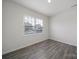 Well-lit bedroom with neutral walls, wood-look floors, and a large window at 300 Kennerly Center Dr, Mooresville, NC 28115