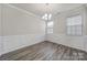 Formal dining room featuring wood-style floors, wainscoting, chandelier, and large windows at 300 Kennerly Center Dr, Mooresville, NC 28115