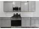 Close up of kitchen with stainless steel range, microwave and gray cabinets and subway tile backsplash at 300 Kennerly Center Dr, Mooresville, NC 28115