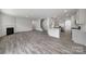 Open-concept living area with wood-style floors, fireplace, and a staircase leading to the upper level at 300 Kennerly Center Dr, Mooresville, NC 28115