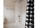 Bathroom featuring a white tub, white tile surround, brushed nickel fixtures, toilet and patterned shower curtain at 3009 Ocaso Ct, Matthews, NC 28104