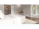 Bright bedroom featuring hardwood floors, a stylish console table, and an attached bathroom at 3009 Ocaso Ct, Matthews, NC 28104