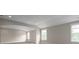 This bonus room has neutral paint, carpet, and large windows that let in natural light at 3009 Ocaso Ct, Matthews, NC 28104