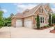 Spacious three car garage with a paved driveway and exterior brickwork to match the house at 3009 Ocaso Ct, Matthews, NC 28104