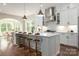 Bright, modern kitchen features white cabinetry, stainless steel appliances, and a large island with seating at 3009 Ocaso Ct, Matthews, NC 28104
