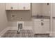 Clean laundry room with a black-and-white patterned floor and white cabinets at 3009 Ocaso Ct, Matthews, NC 28104
