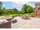 Outdoor patio with wicker furniture and a table, overlooking the manicured lawn and pool at 3009 Ocaso Ct, Matthews, NC 28104