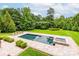 Inviting backyard pool and spa surrounded by lush greenery, manicured grass, and lounge chairs at 3009 Ocaso Ct, Matthews, NC 28104