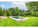 Backyard pool featuring pristine green lawn and mature shade trees at 3009 Ocaso Ct, Matthews, NC 28104
