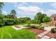 Inviting backyard pool with an expansive patio area and an outdoor dining set, surrounded by lush greenery at 3009 Ocaso Ct, Matthews, NC 28104