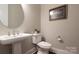 Elegant powder room featuring a pedestal sink, toilet, and decorative artwork at 3009 Ocaso Ct, Matthews, NC 28104
