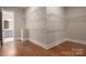Spacious walk-in closet featuring hardwood floors, white shelves, and natural light coming through door at 3009 Ocaso Ct, Matthews, NC 28104