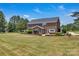 Expansive backyard features a brick home with a stone patio and well-maintained lawn at 3068 River Rd, Shelby, NC 28152