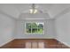 Minimalist bedroom with hardwood floors, a large window offering verdant views, and neutral walls at 3068 River Rd, Shelby, NC 28152