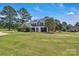 Sprawling front lawn and mature trees enhance the curb appeal of this attractive home at 3068 River Rd, Shelby, NC 28152