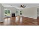 Spacious living room with hardwood floors, fireplace, large windows, and a ceiling fan at 3068 River Rd, Shelby, NC 28152