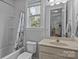 Bathroom with tub/shower combo and large window, next to the toilet and sink vanity at 308 Planters Way, Mount Holly, NC 28120