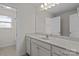 Bright bathroom featuring double sinks, white cabinetry, and a large mirror, creating a spa-like retreat at 308 Planters Way, Mount Holly, NC 28120