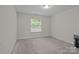 Neutral bedroom offering carpeted floors, a window and a heater unit at 308 Planters Way, Mount Holly, NC 28120