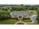 Aerial view of the community building featuring stone accents, manicured landscaping, pool, playground, and American flag at 308 Planters Way, Mount Holly, NC 28120