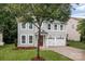 Charming two-story home with a well-manicured lawn and a two-car garage, blending classic design with modern convenience at 308 Planters Way, Mount Holly, NC 28120