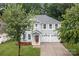 Charming two-story home with a well-manicured lawn and a three-car garage, blending classic design with modern convenience at 308 Planters Way, Mount Holly, NC 28120