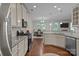 Beautiful kitchen with stainless steel appliances, granite countertops, and hardwood floors, flowing into a dining area at 308 Planters Way, Mount Holly, NC 28120