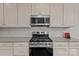 Modern kitchen with stainless steel appliances, granite countertops, and white cabinetry, offering a stylish cooking space at 308 Planters Way, Mount Holly, NC 28120