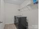 Laundry room includes washer, dryer, storage shelving, and tile floors at 308 Planters Way, Mount Holly, NC 28120