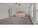 Spacious primary bedroom with plush carpeting, a tray ceiling, and a walk-in closet at 308 Planters Way, Mount Holly, NC 28120